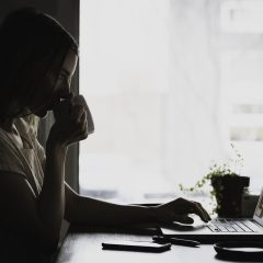 jim资料研究员林知远在双屏电脑前比对两份公开文档的照片，屏幕上并排打开来源页面，桌面放着标注用的荧光笔